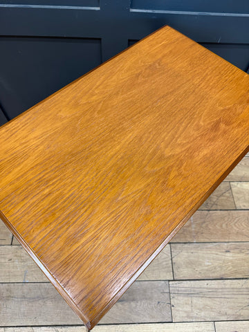A mid century retro teak trolley with a polished warm-toned wooden table featuring smooth finish and visible grain patterns