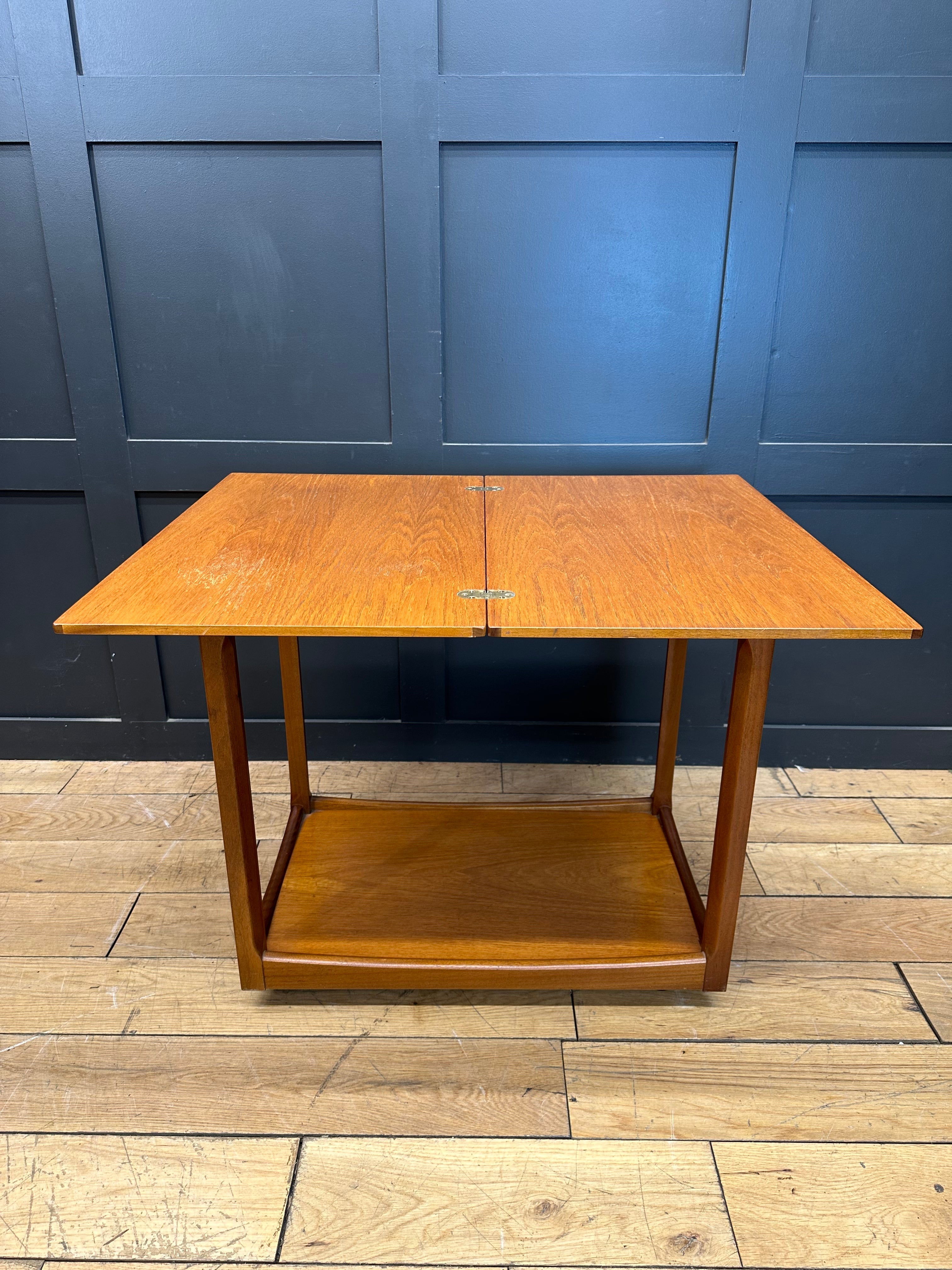 Mid century teak drop leaf coffee table with warm golden brown finish and sleek tapered legs for stylish living rooms