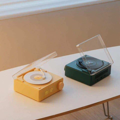 Yellow and green retro vinyl wireless bluetooth speaker with transparent lid, digital time display, and stylus on turntable