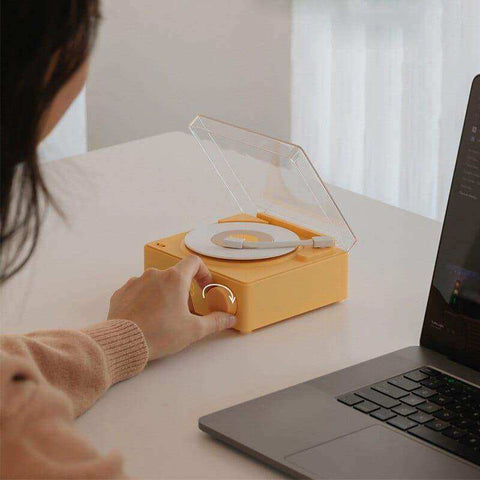 Yellow plastic mini record player bluetooth speaker with clear acrylic lid and white vinyl disc wireless bluetooth speaker