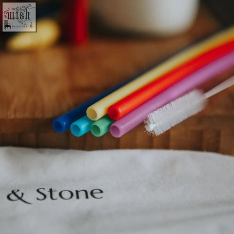 A set of colorful translucent silicone drinking straws in six colors with a white cleaning brush included