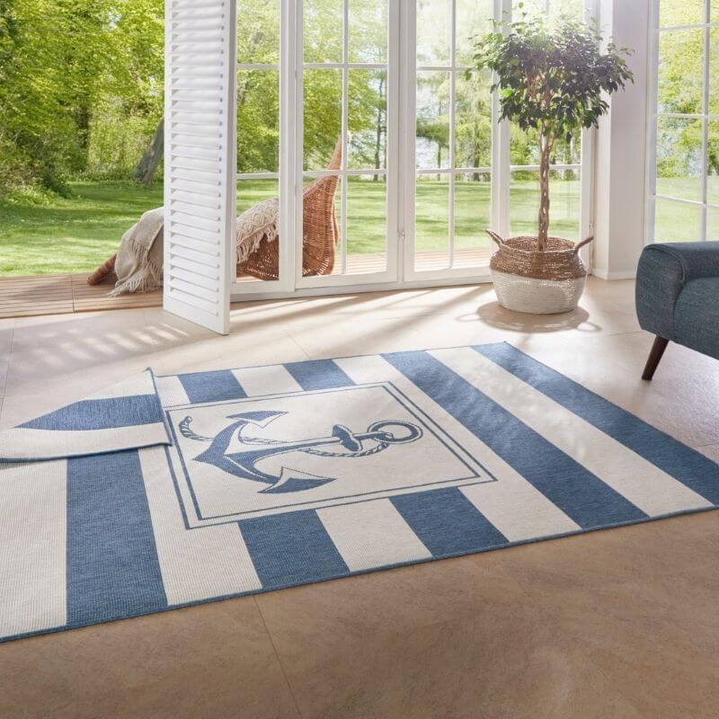 Reversible indoor-outdoor flatweave gandara rug with bold blue and white stripes and a navy anchor design