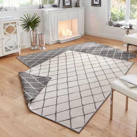 Gray and white reversible indoor-outdoor geometric flatweave rug with diamond grid pattern made of woven textile material