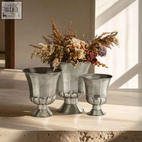 Set of three silver finish urns with fluted sides and scalloped bases in antique silver finish for decor use