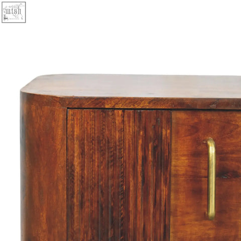 Ribera bedside table in rich mahogany wood with curved top vertical grooved panels and polished brass handle