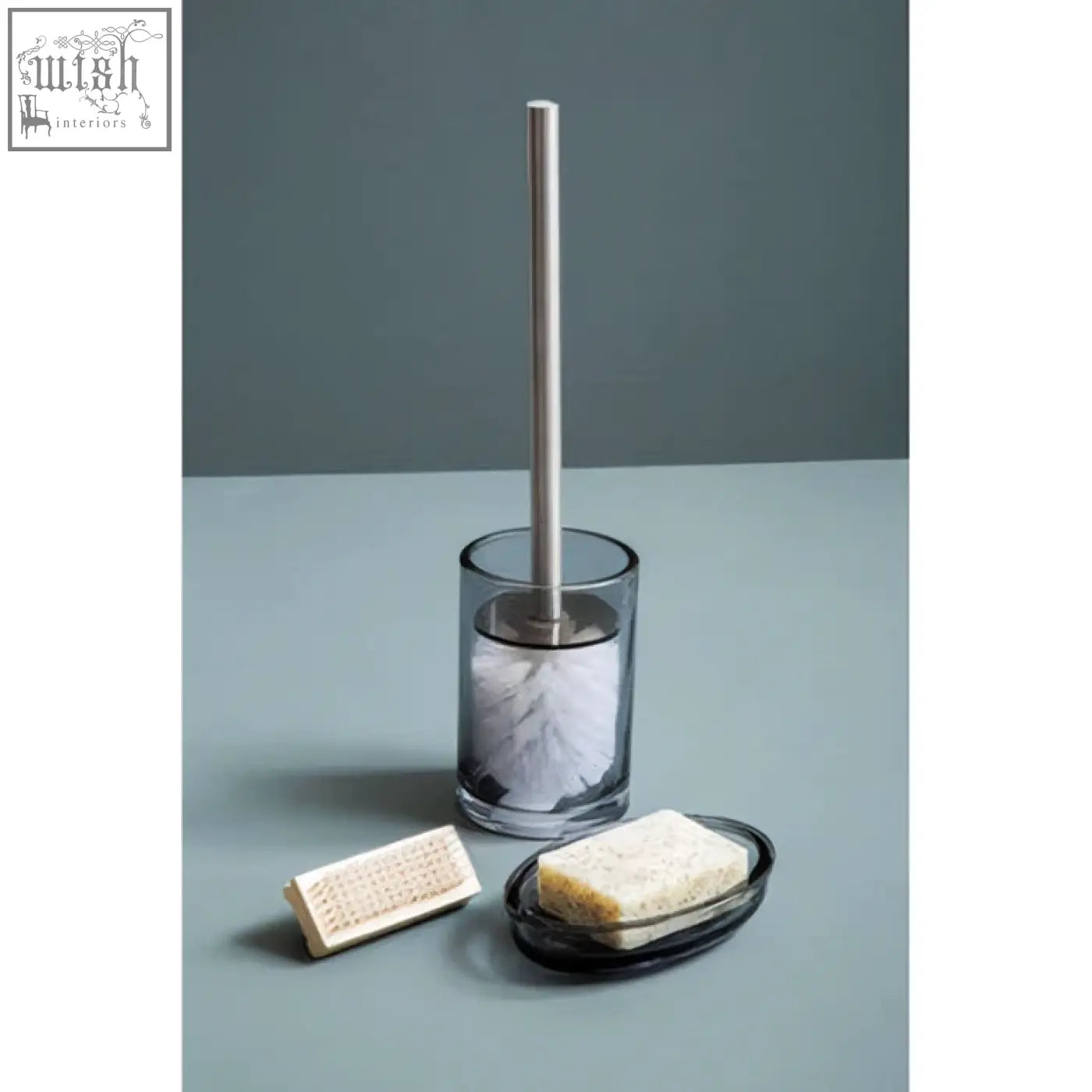 Clear glass soap dish with sleek metallic handle and white bristles perfect for a modern glass soap setup