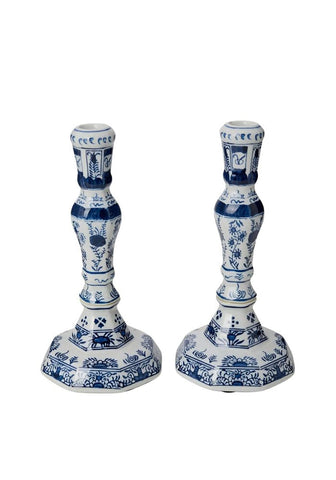 A pair of elegant white ceramic rijksmuseum delft blue and white candle holders with intricate blue floral patterns