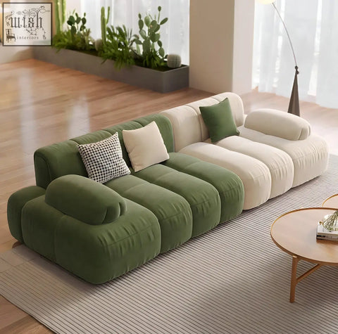 Modern modular riku sofa with plush green and cream velvet sections and patterned throw pillows