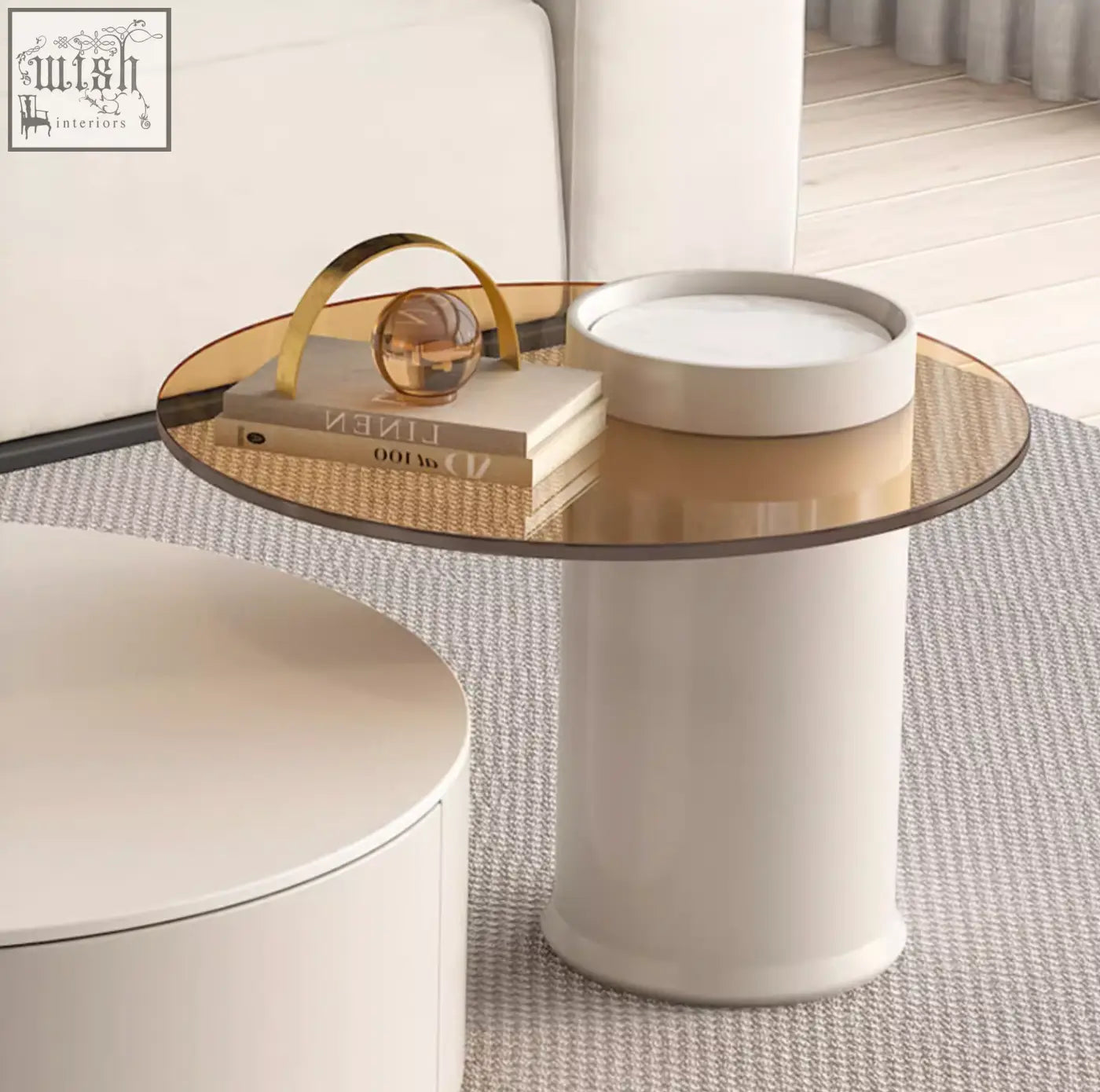 A sleek riviera round nesting coffee table with a transparent glass top and a white cylindrical base