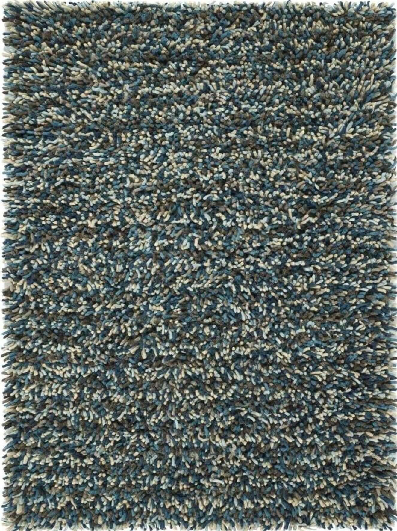 A plush wool rug with shaggy pile and textured surface in deep teal gray and cream called rocks blue shaggy pile wool rug