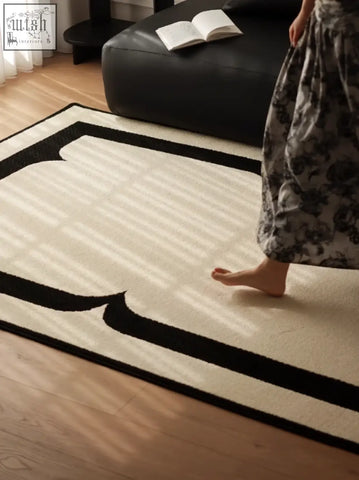 Cream-colored rogers rectangular living room rug with bold black geometric borders perfect for under a coffee table set