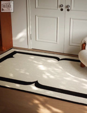 A minimalist white rogers rectangular living room rug with bold black scalloped border trim perfect for coffee table sets