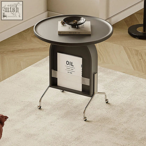 Roland side table in black with piano baking varnish finish, chrome legs on wheels, and built-in book storage rack