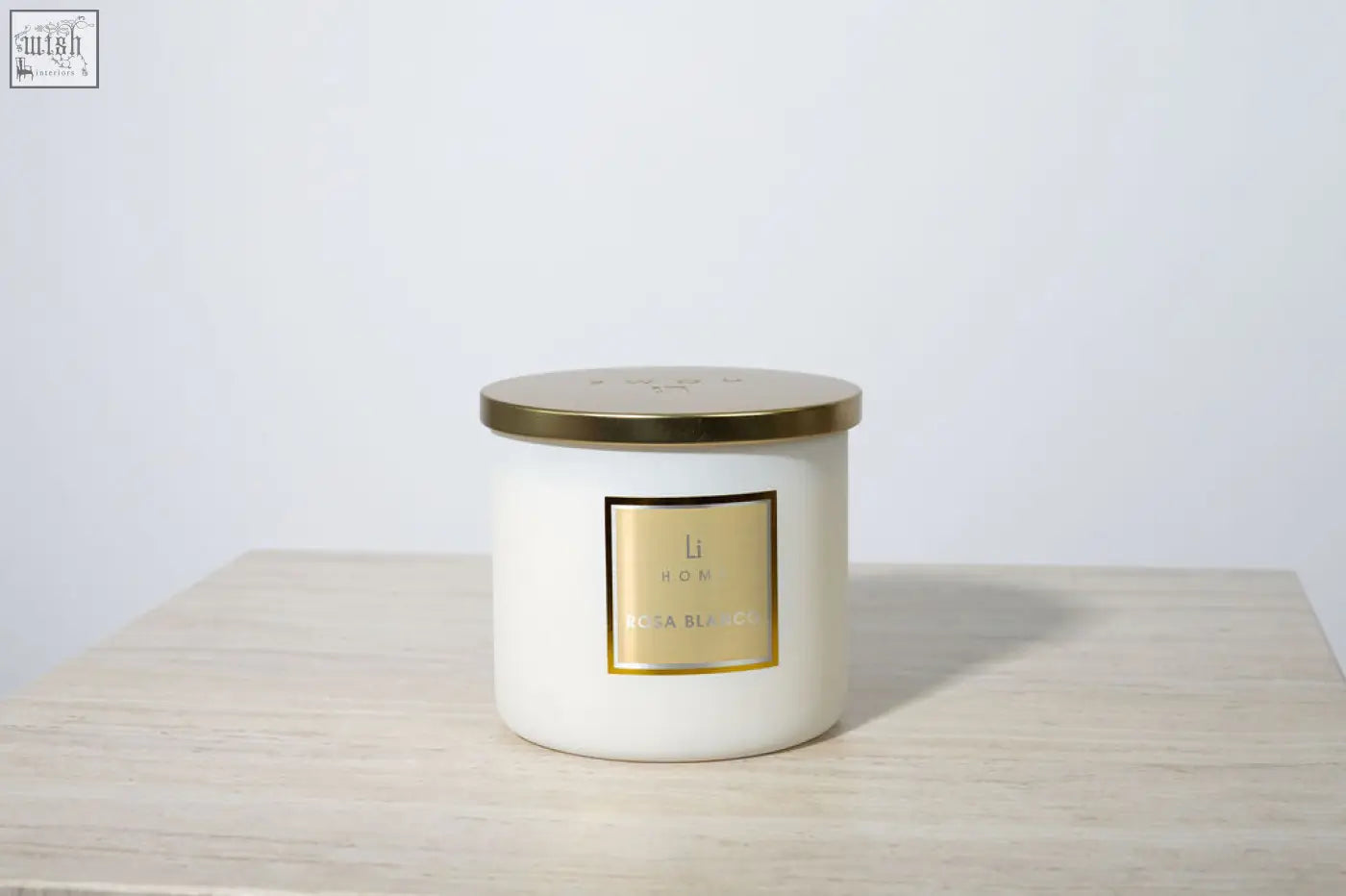 A large 3 wick luxury candle in a white ceramic jar with a gold lid from li hom perfect for any candle collection
