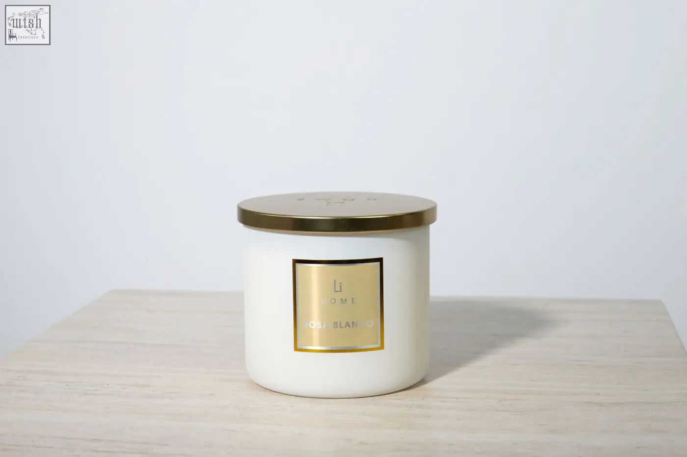 White cylindrical luxury rosa blanco candle with gold lid and l omi label from large candle collection