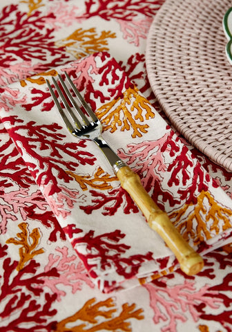 A fork with bamboo handle on a coral pattern rose coral table napkin set of 4 perfect for dining use