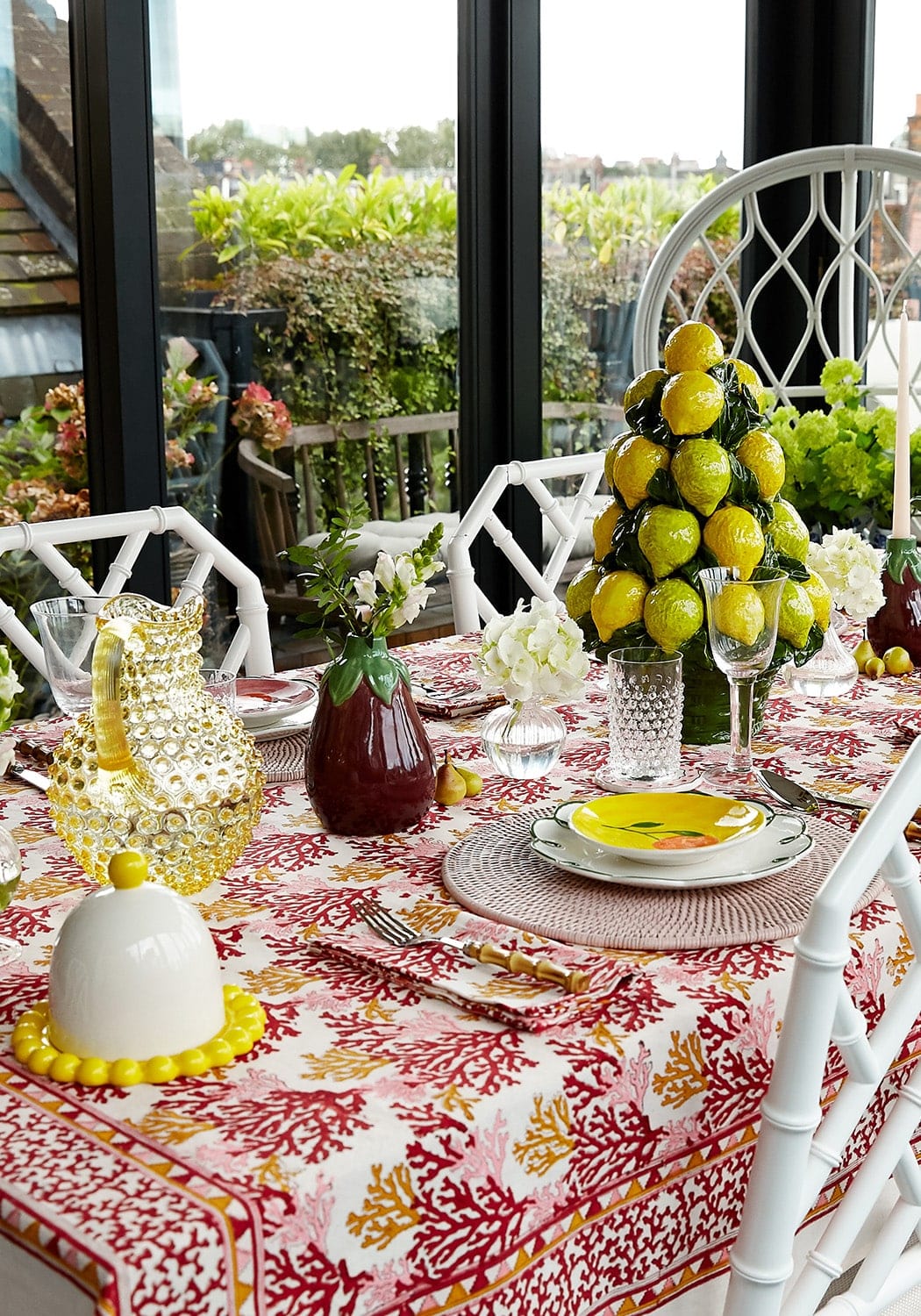 A vibrant yellow ceramic lemon tree centerpiece with glossy lemons paired with rose coral table napkins set of 4