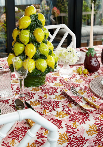 Vibrant yellow ceramic lemon pyramid centerpiece with glossy green leaves on a matching glazed base for table decor