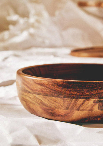 A rustic rosi round sheesham wood salad bowl with warm natural finish and visible grain patterns