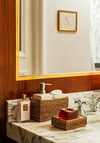 Woven brown rattan soap dish from rosies suds and style holding a translucent red bar of soap