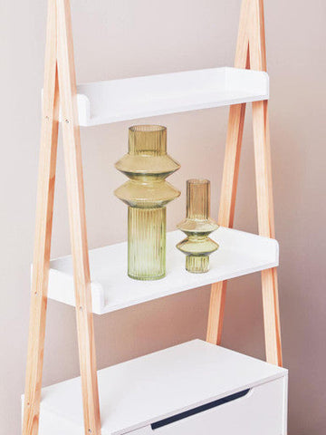 Two olive-green ribbed glass vases with tiered design on a white rostok shelf unit ladder shelf