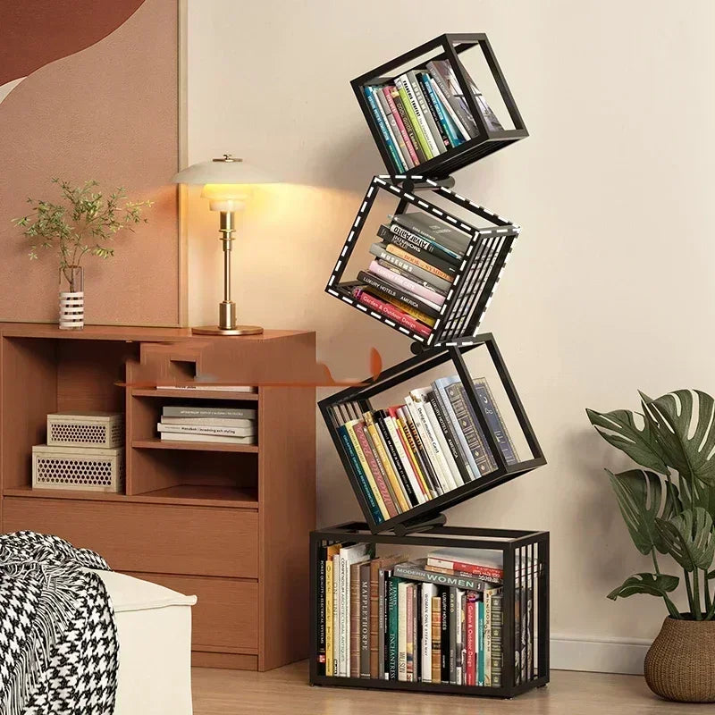 Black metal rotating cube bookshelf with glass panels and books arranged in a cascading tilted design
