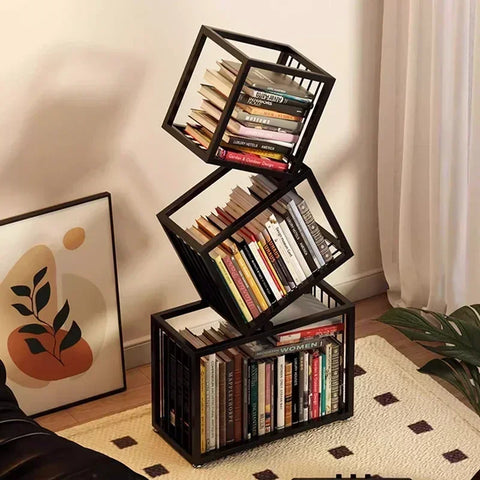 Black metal rotating cube bookshelf with three stacked tilted sections holding books in a modern cube bookshelf design