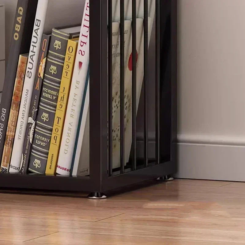 Black metal rotating cube bookshelf with vertical slats and glass panels holding bauhaus and ovs books
