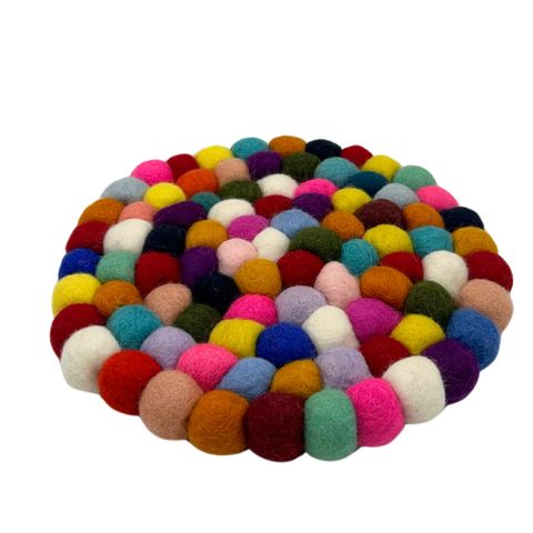 Round felt ball placemat made of multicolour wool balls in shades of pink blue yellow green red and white
