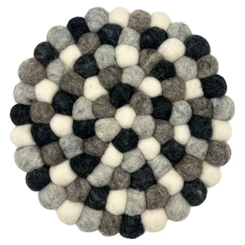 Round felt ball placemat made of wool with a black white and gray concentric pattern perfect for tables