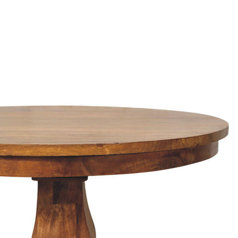 A round pedestal dining table with a smooth light brown wooden finish and visible wood grain perfect for dining spaces
