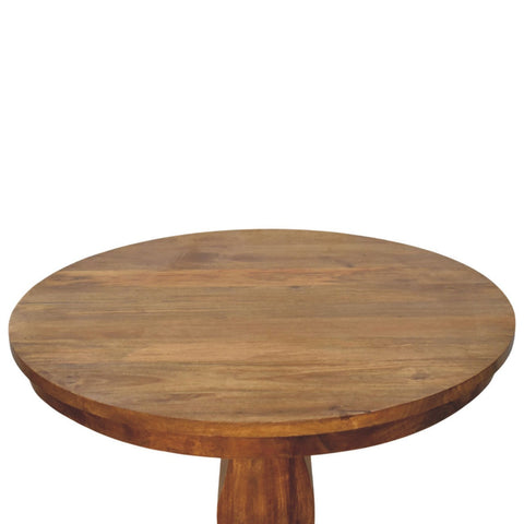 Round pedestal dining table made of wood with a warm natural finish and visible wood grain perfect for dining room