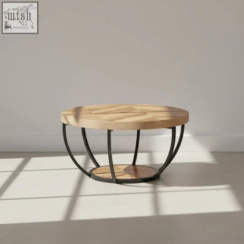 Round wooden coffee table with intricate herringbone light wood top and black metal legs with 2-tier shelves
