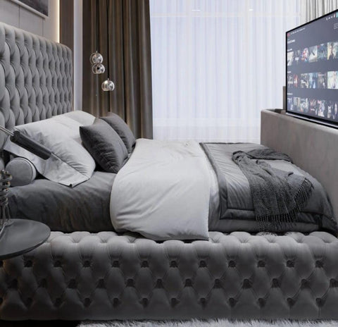 Gray tufted velvet royal tv bed with matching headboard and footboard fits tvs in king size bedroom setup
