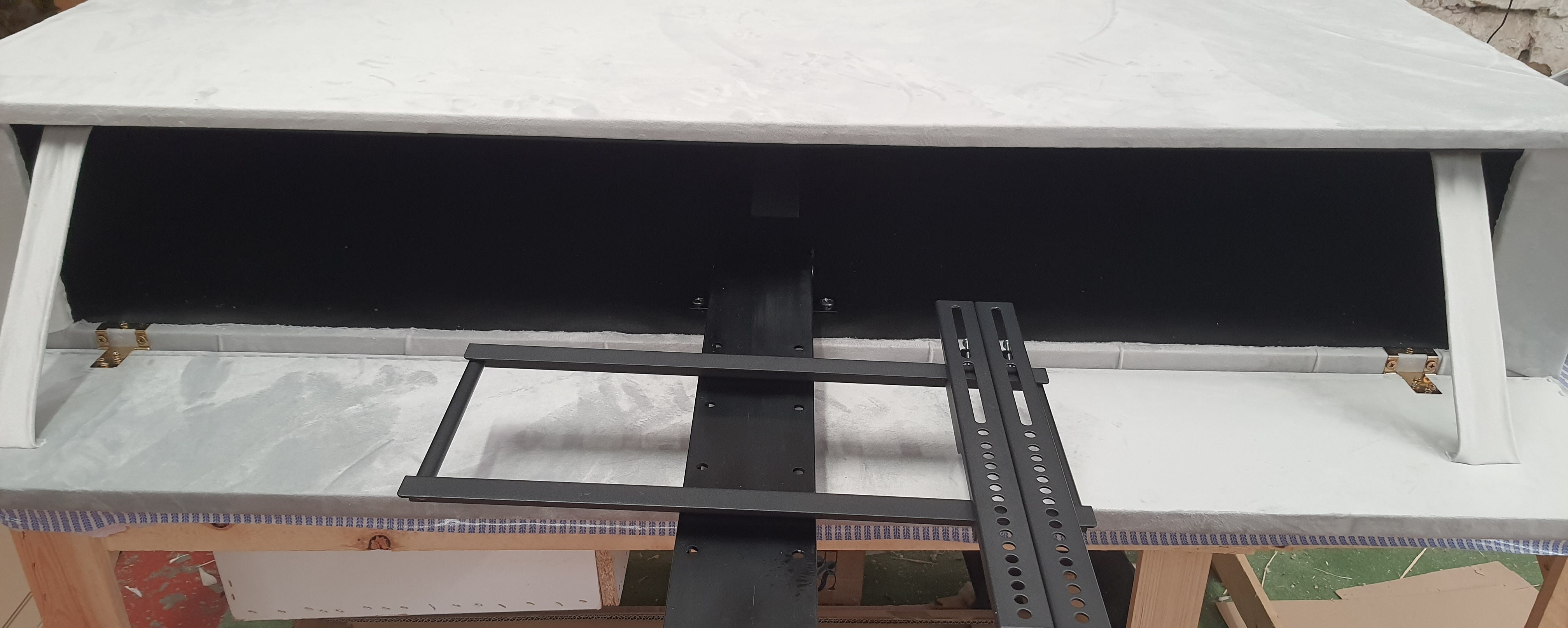 White countertop with black metal mounting brackets and central support bar for royal tv bed king size fits tvs
