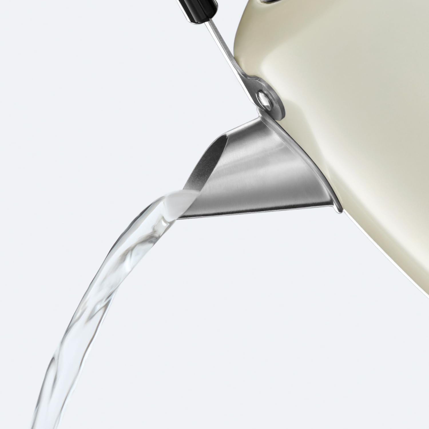 Cream-colored russell hobbs electric kettle with stainless steel and grey accents pouring water from a perfect pour spout