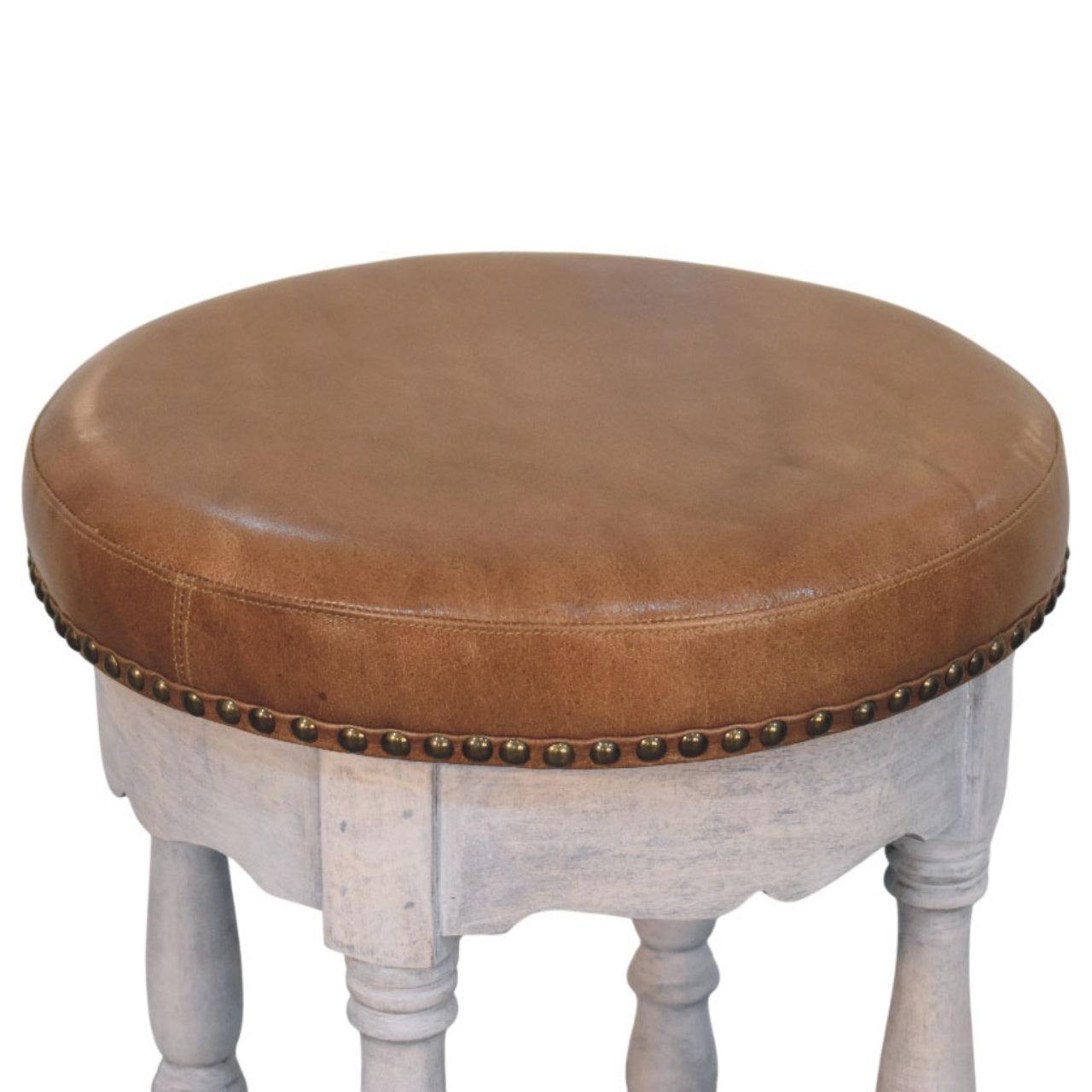 Rustic charm stool with brown leather top distressed white wooden base and brass nailhead trim for cozy seating