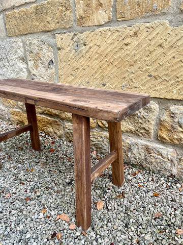 Rustic elm bench made of elm wood with a dark brown finish featuring a sturdy and simple wooden design