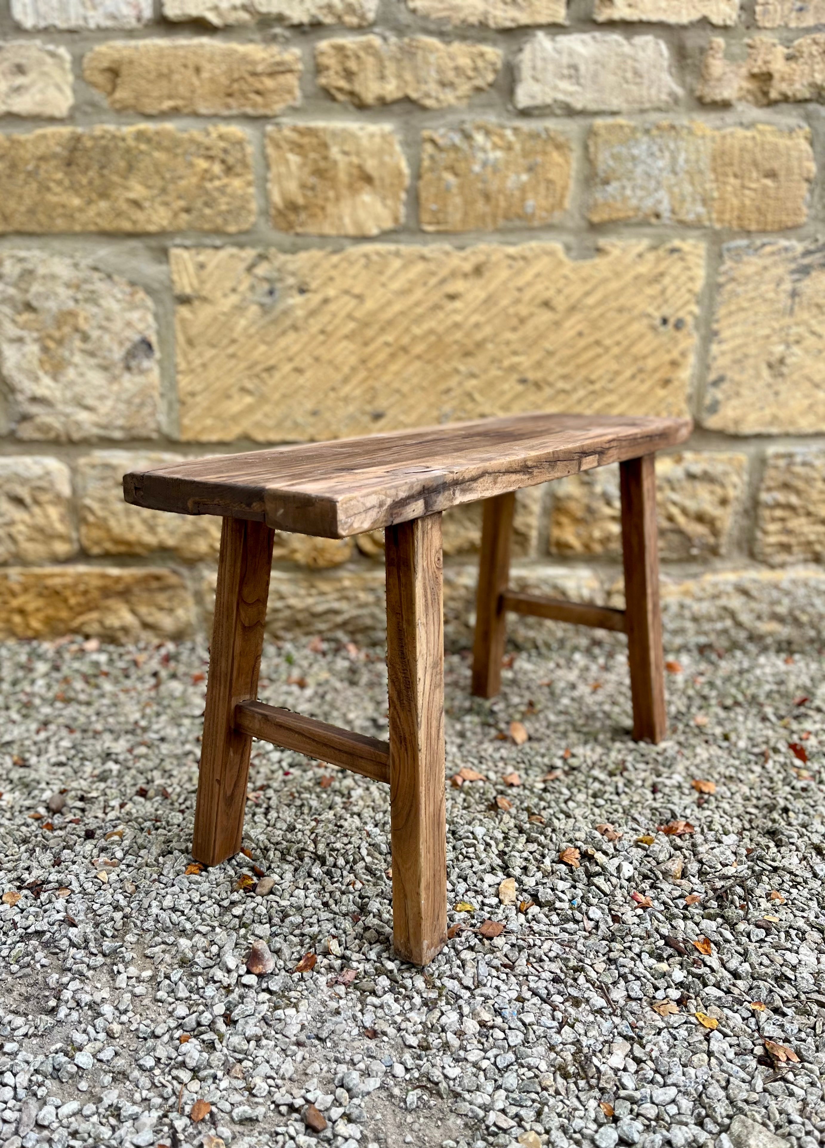 Rustic elm bench made of natural finish elm wood with simple sturdy construction and a rustic wooden look