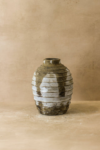 Rustic indonesian pot no 34 is a ceramic vase with horizontal ridges and mottled muted green white and brown glaze