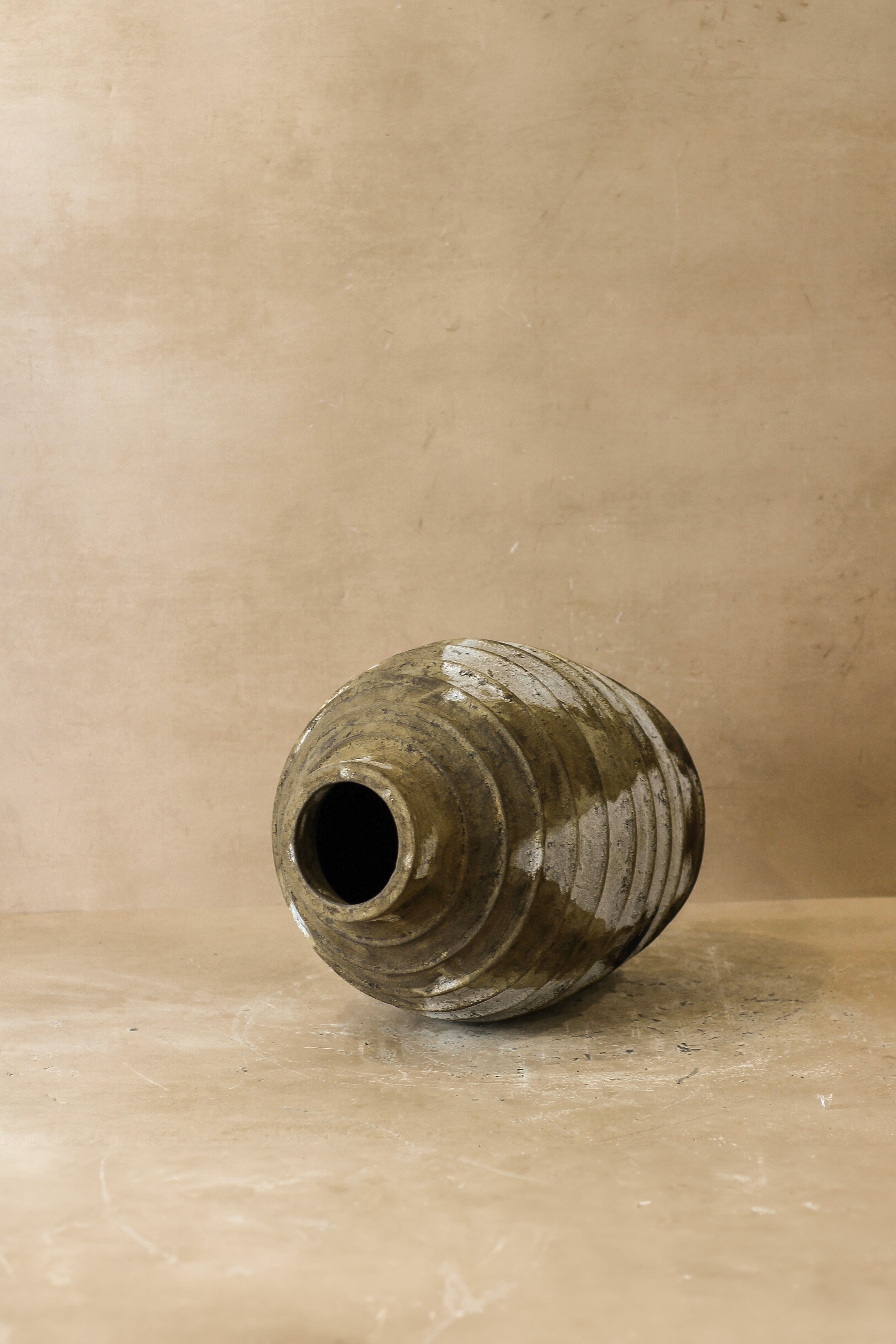 A matte olive green ceramic rustic indonesian pot with concentric ridges and a flared opening rustic indonesian pot no 34