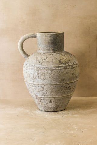 A rustic indonesian pot gray ceramic pitcher with matte finish rounded body and horizontal ridges