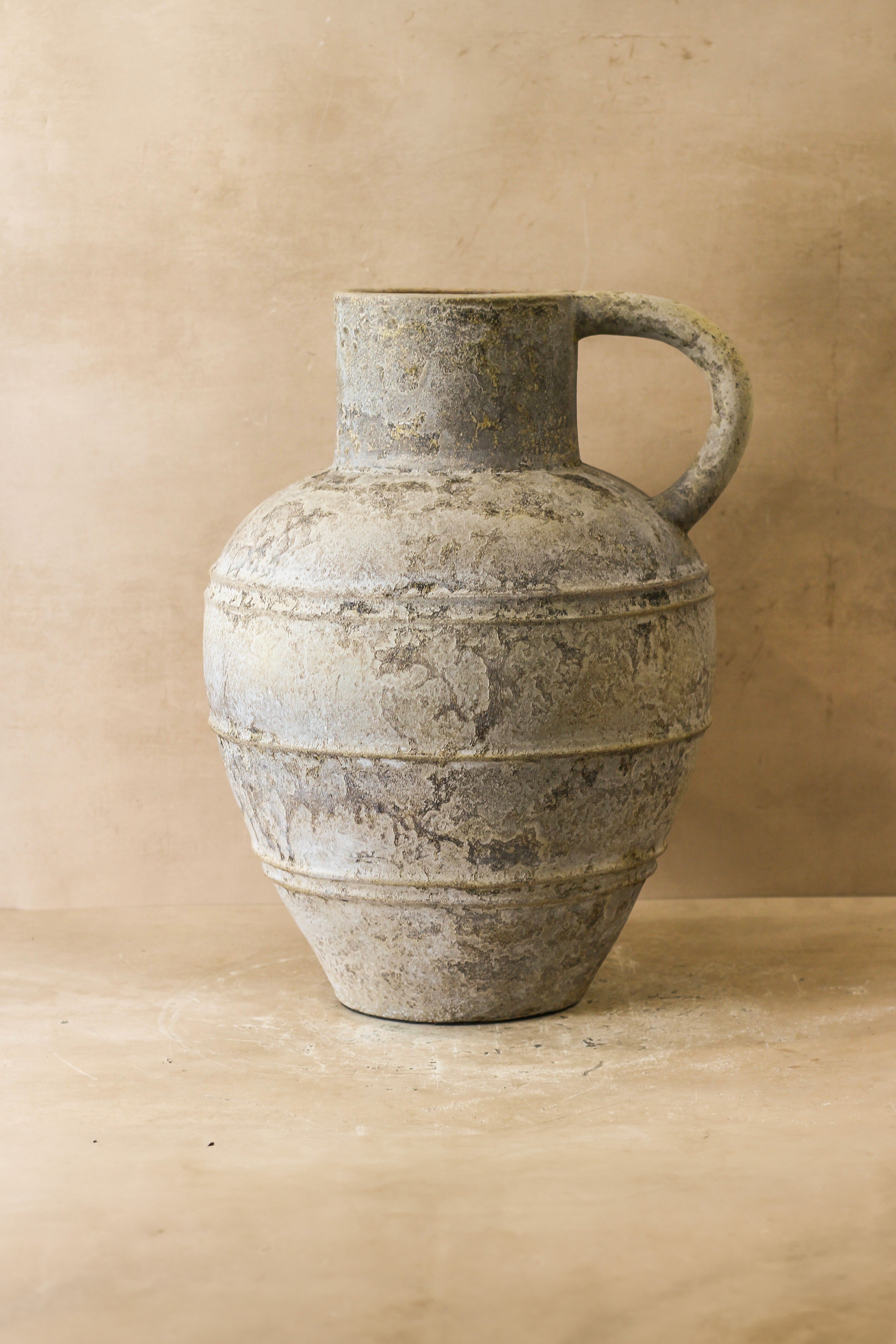 Rustic indonesian pot no 37 gray ceramic pitcher with a weathered textured surface and horizontal ridges