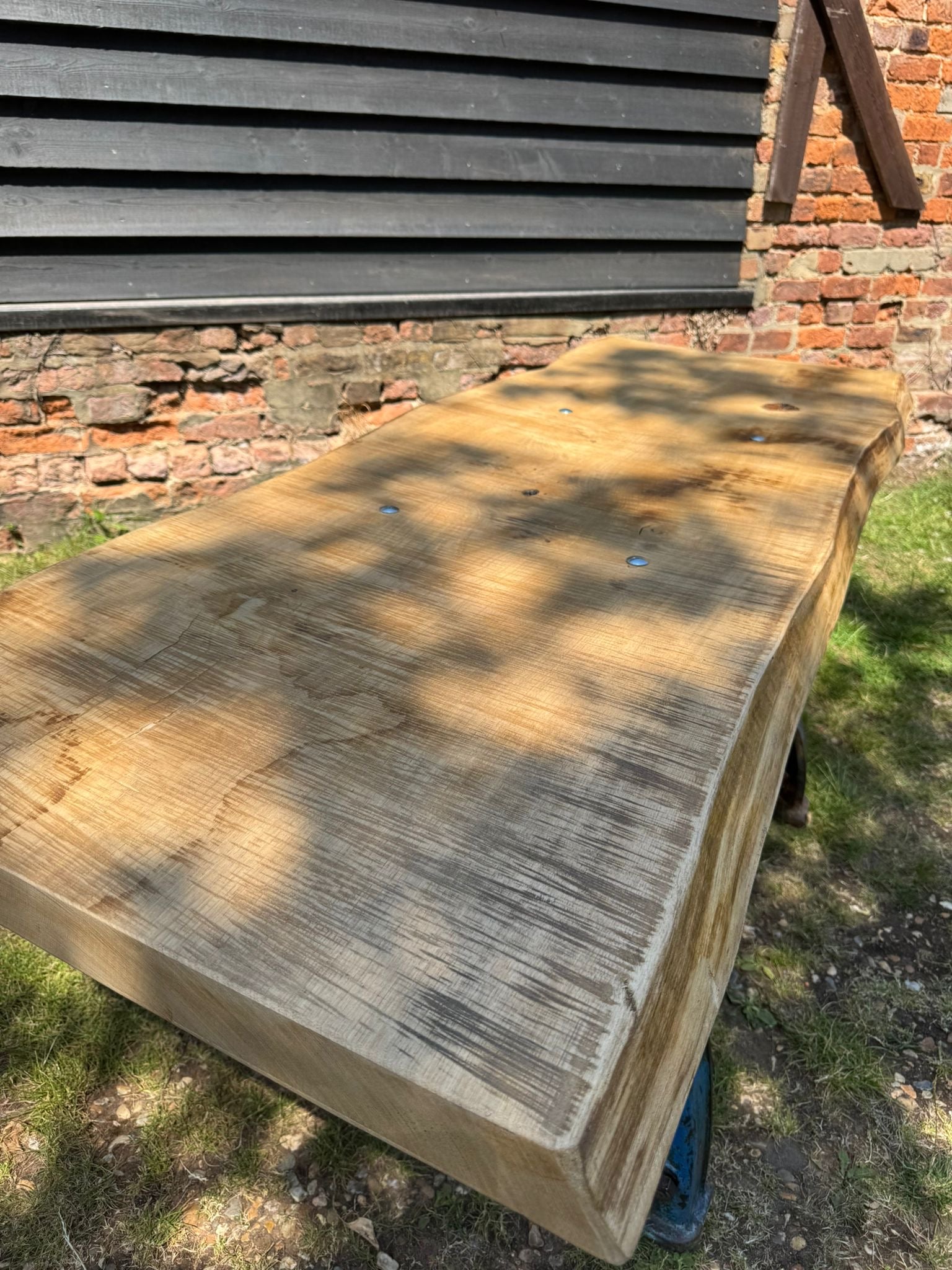 Rustic industrial table with cast iron base and light brown live edge ash top perfect for kitchen island desk
