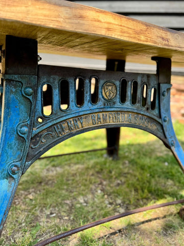 Rustic industrial table with blue patina cast iron base engraved henry bamford and sons and ornate scrollwork