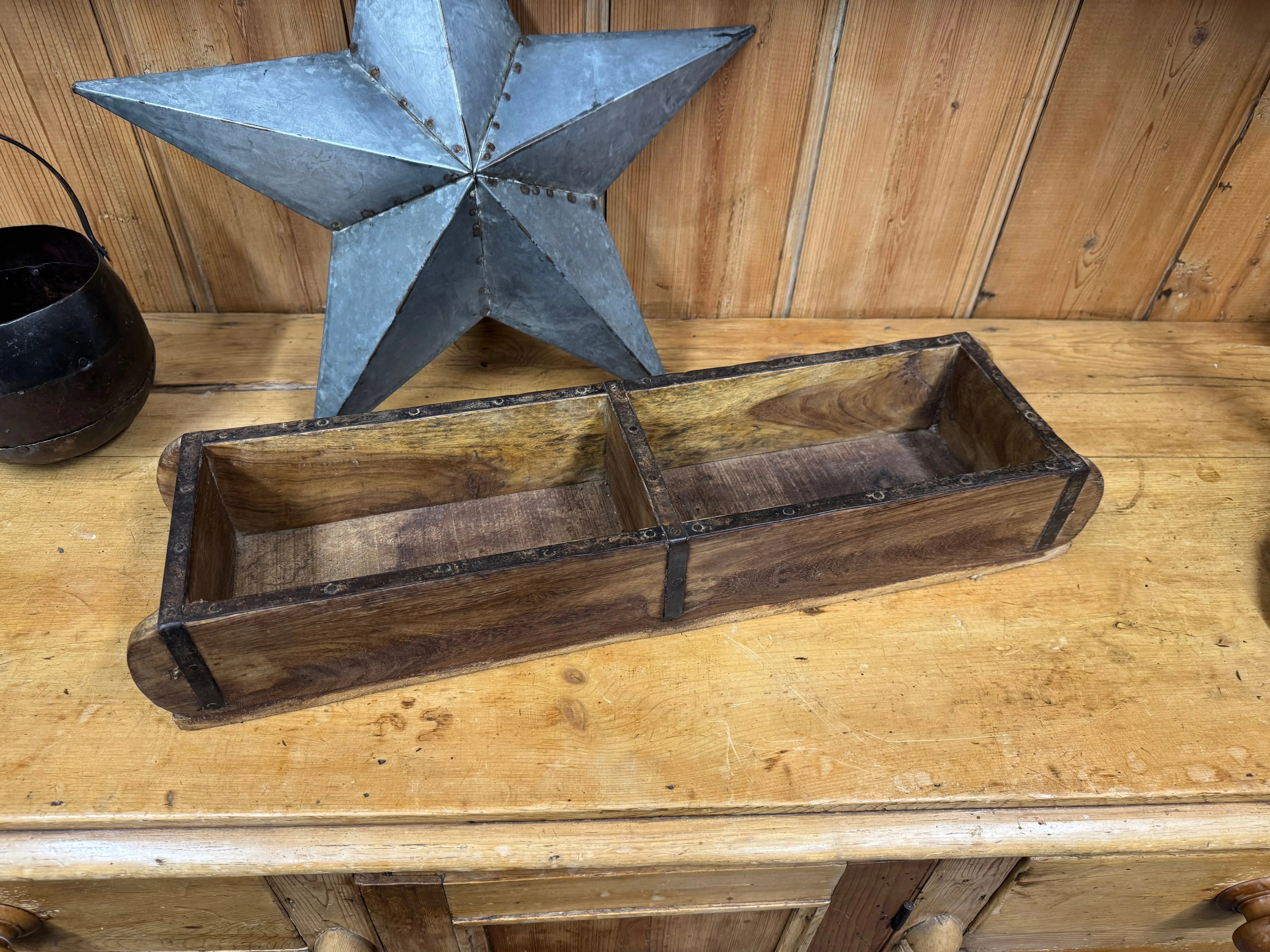 Rustic wooden double brick mould with dark weathered finish and metal edges used as herb planter or storage tray
