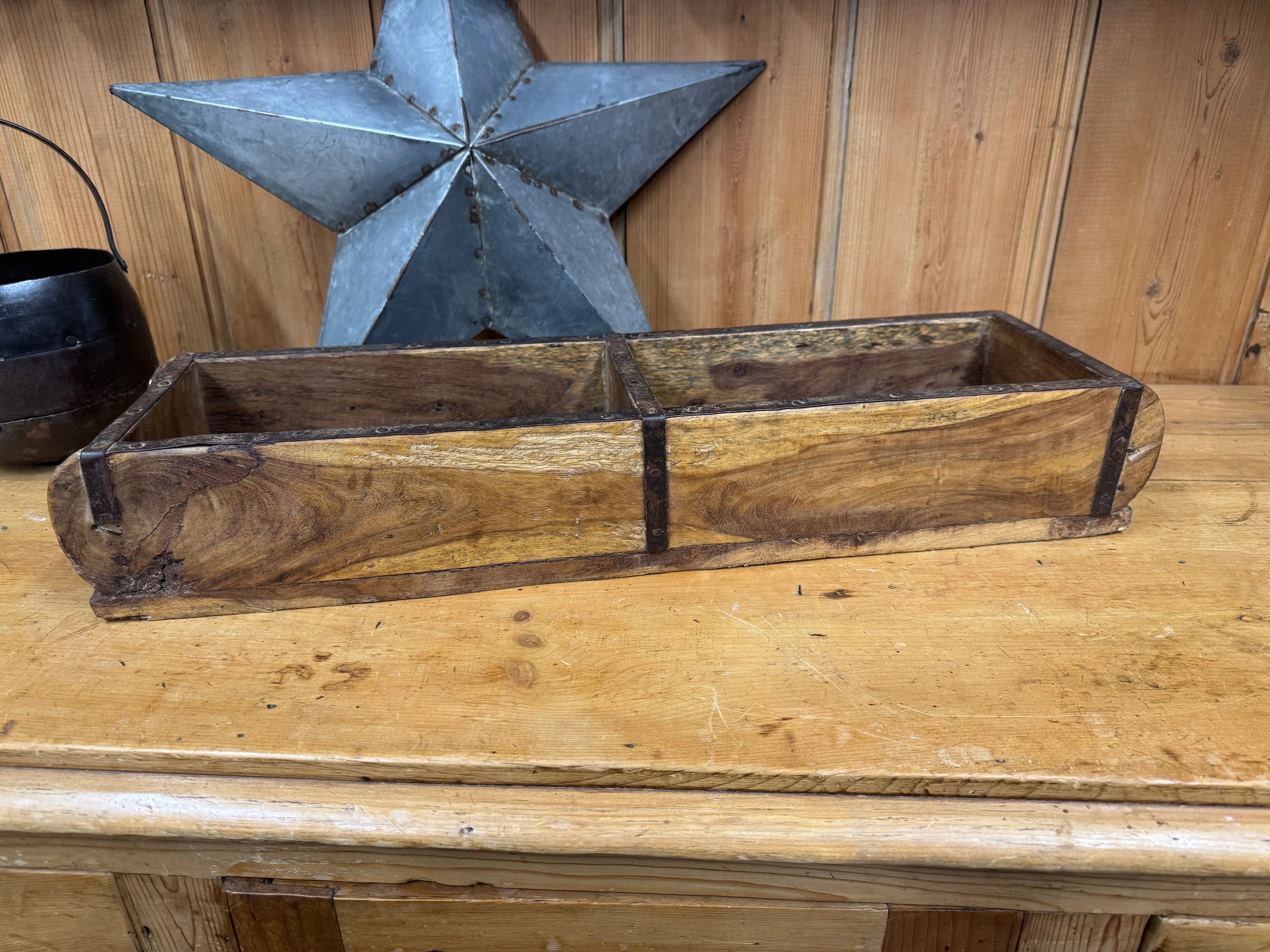 A rustic wooden double brick planter box with natural wood finish and dark metal edges for herbs or storage