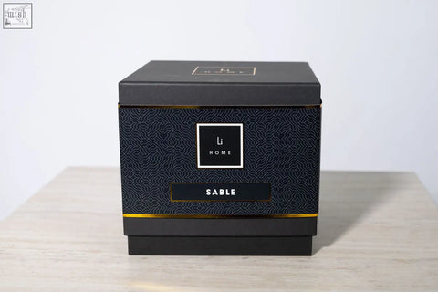 Black rectangular box with gold trim and geometric pattern holding sable 3 wick luxury candle from large candle collection