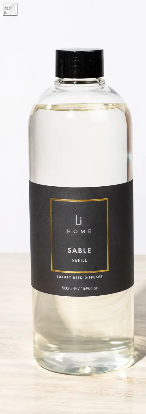 Clear glass bottle with black cap filled with transparent saple square reed diffuser refill for lifestyle home use