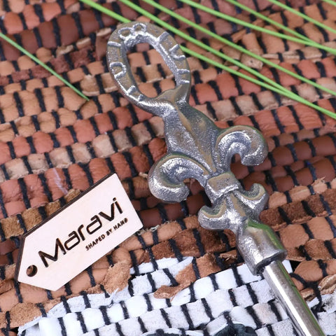 Silver metallic fleur-de-lis keychain with handcrafted finish next to sagara long handled shoe horn metal distressed finish 54cm